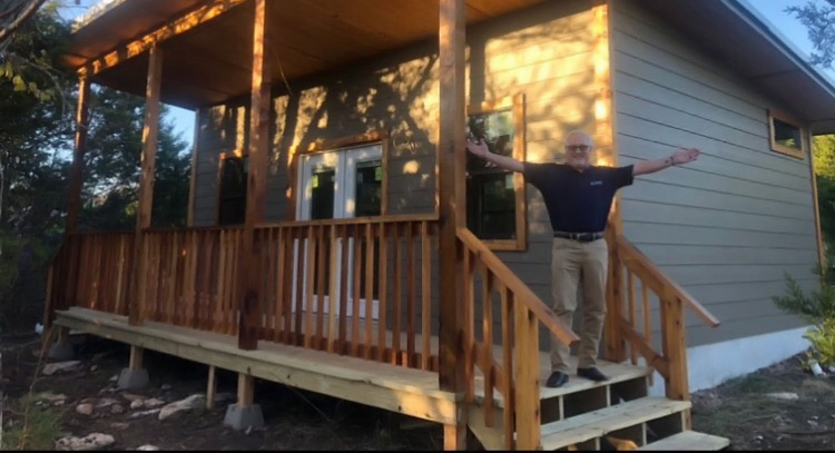 Man standing on porch with arms open